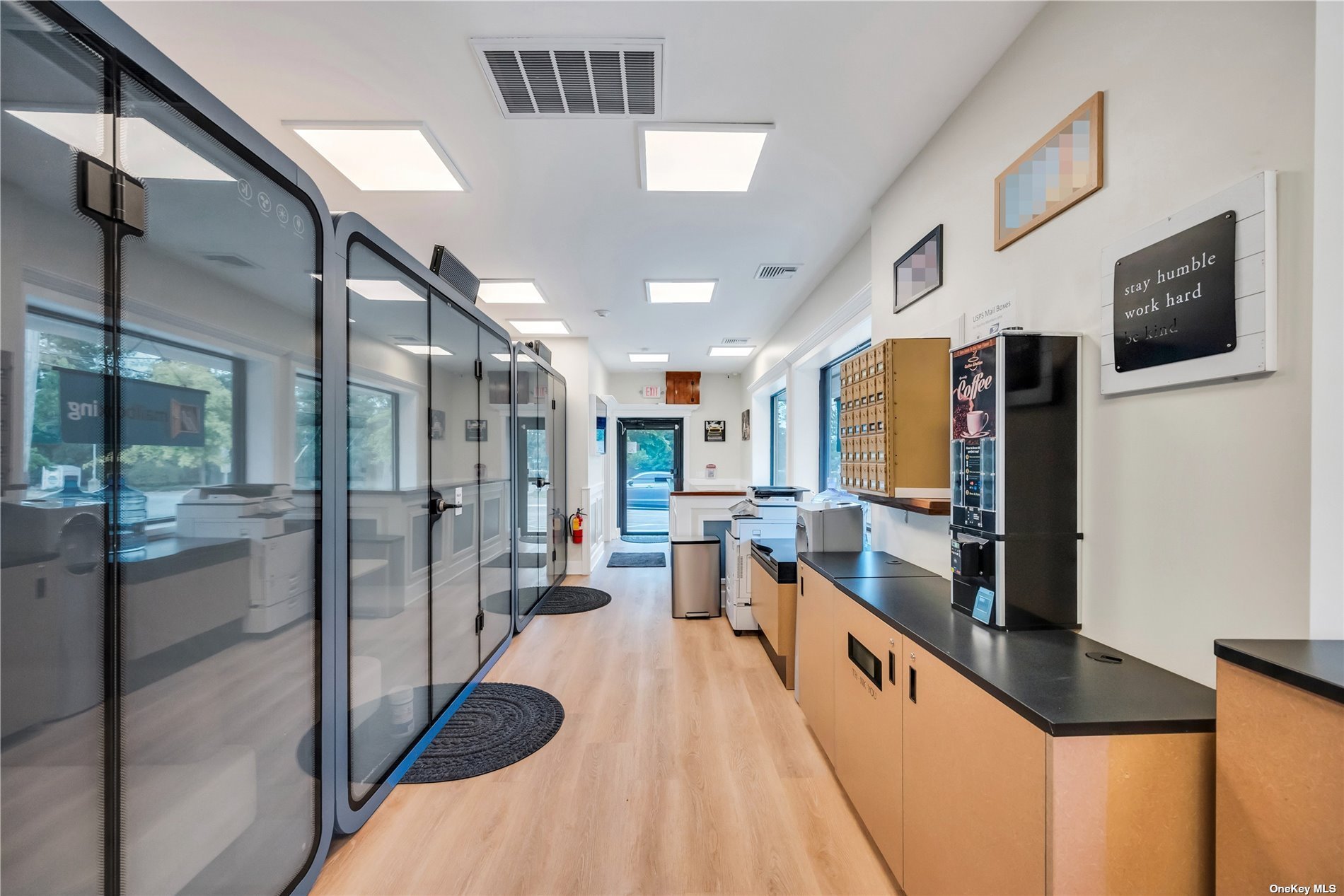 The PodStop hallway with printers, mailboxes, and a coffee machine